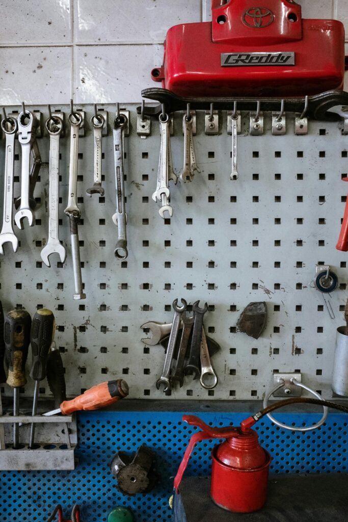 A neatly arranged set of automotive tools hanging on a workshop pegboard, emphasizing organization and efficiency.